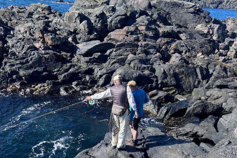Saltwater fly fishing guide in Norway points out fish to guest